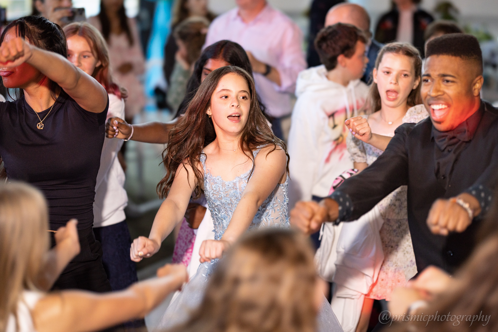 A child dances with the DJ and friends at a bat mitzvah