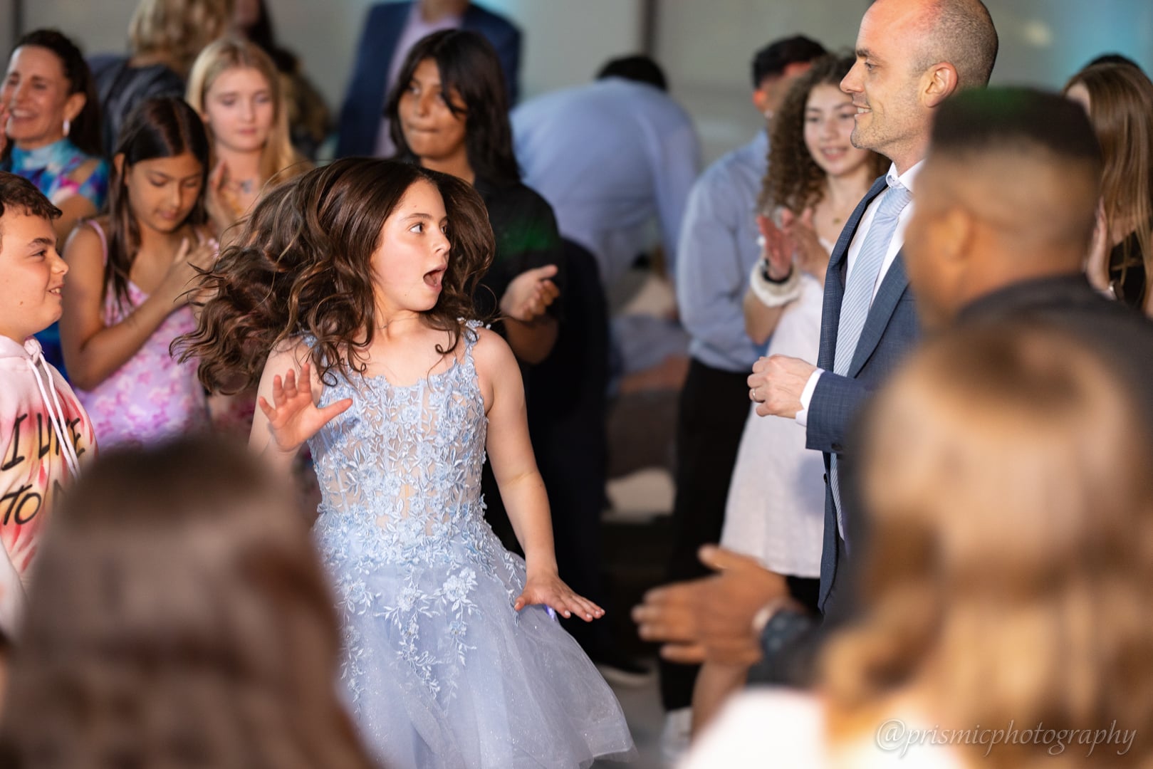 A child dances with her father at a bat mitzvah