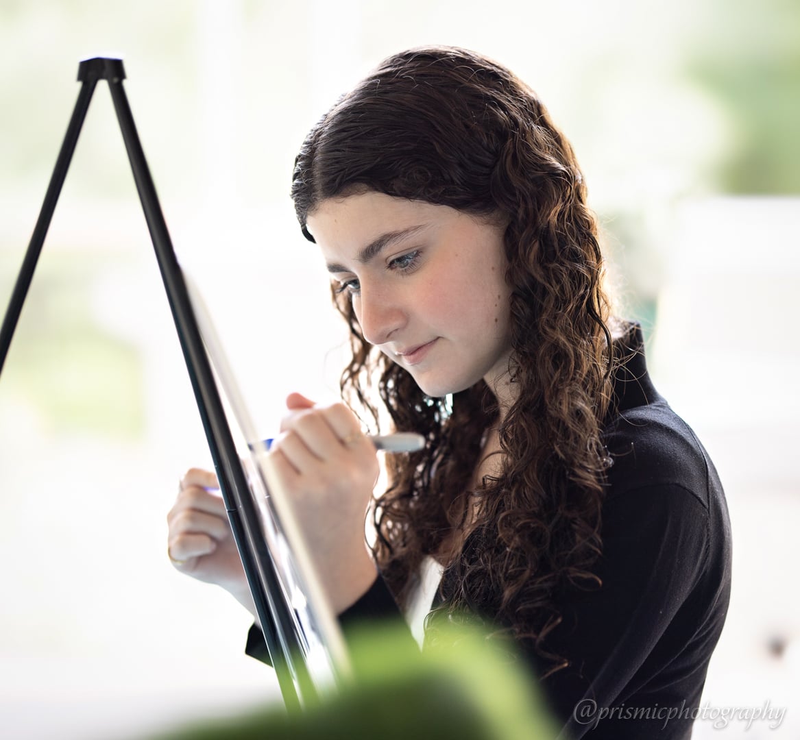 A child autographs a sign at a bat mitzvah
