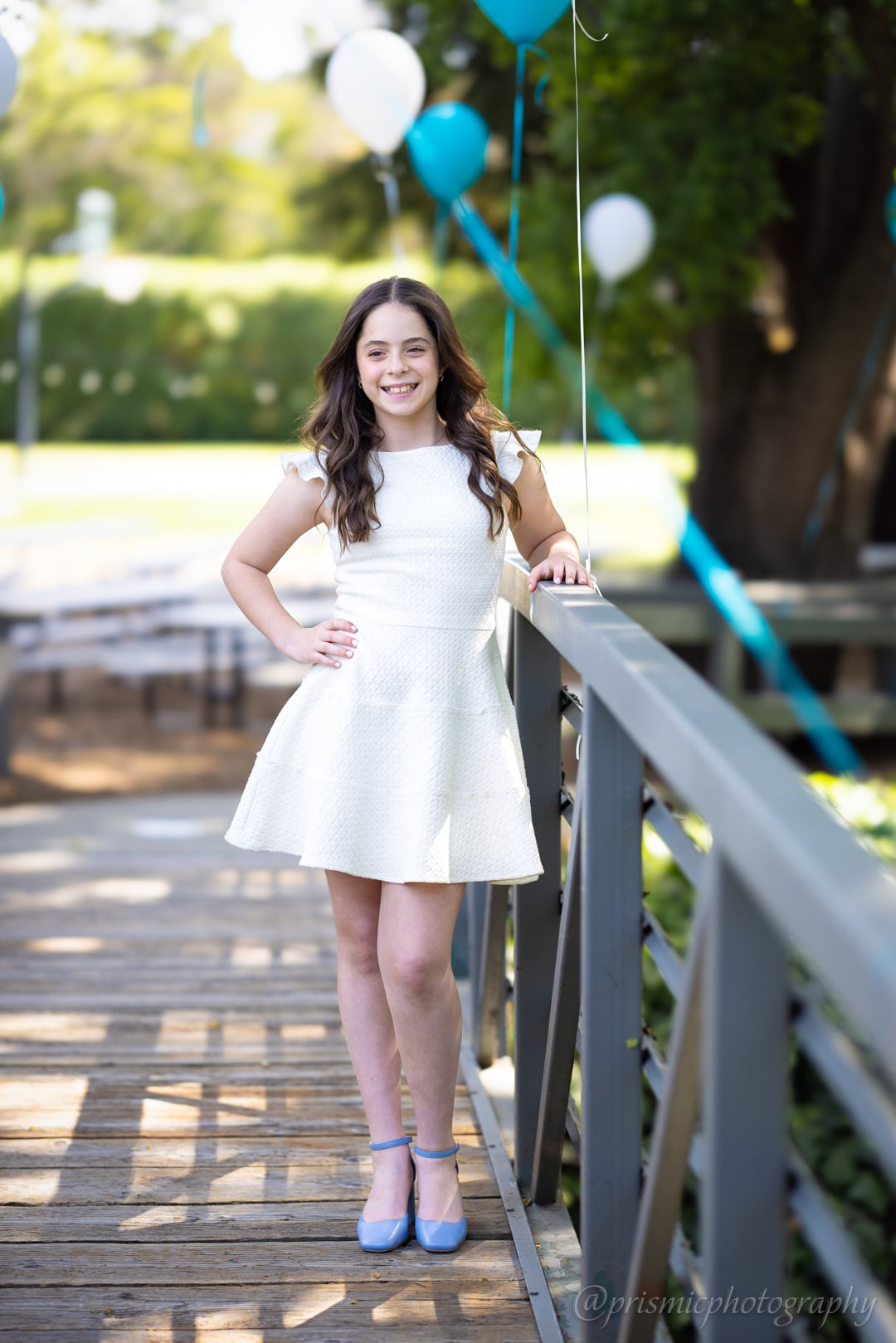 A child poses next to a railing at a bat mitzvah