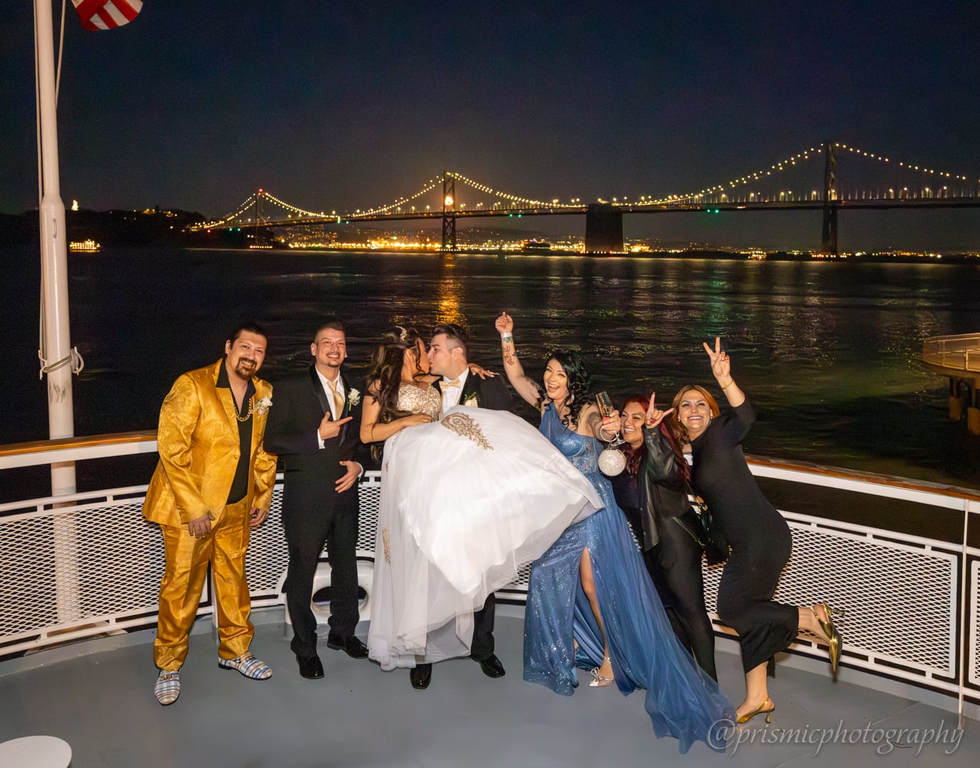 A wedding couple and friends pose for a photo with SF Bay in the background.